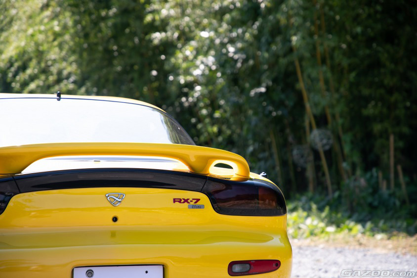 遊園地の舗装で黄色いおもちゃの車を運転している2人の少女。リモコンで電気自動車に乗る子供たち。子供向け娯楽用バッテリー車Premium写真