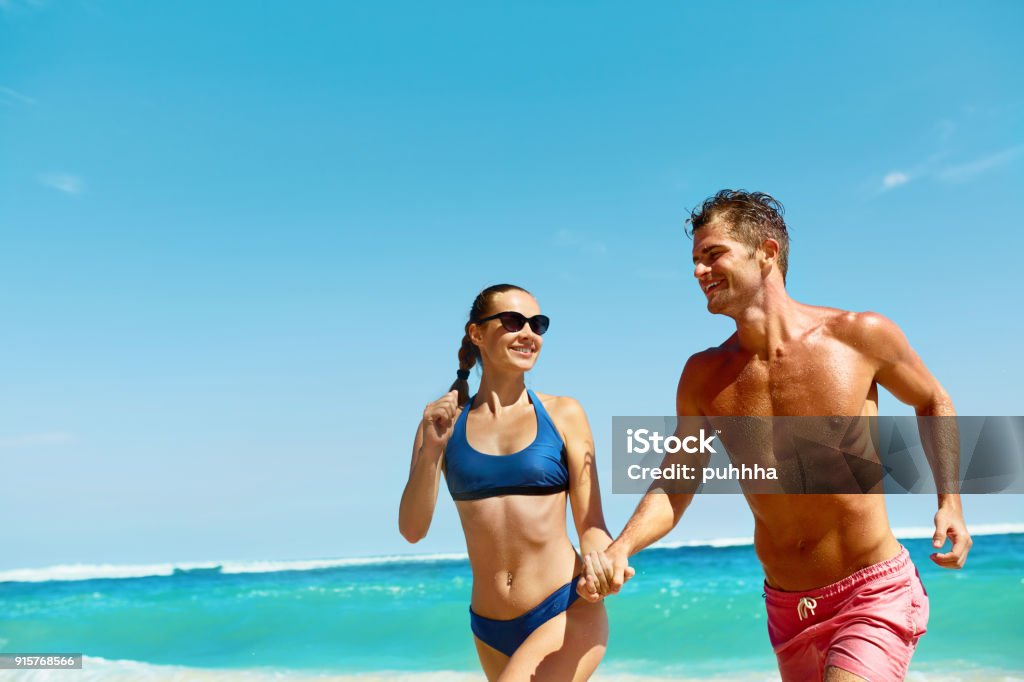 平和な海辺のシーンで海の波と黄金色の光でビーチで夕日に手を握っているロマンチックなカップル, 手を繋いでいるカップル, ビーチの夕日, ロマンチックな カップル背景壁紙画像素材無料ダウンロード