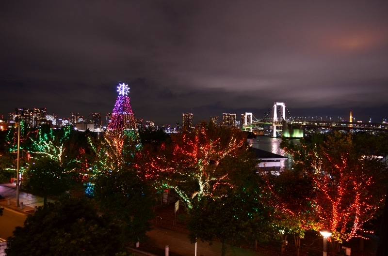 お台場イルミネーションYAKEI」ベイサイドのイルミネーション越しに見るレインボーブリッジ株式会社オマツリジャパン
