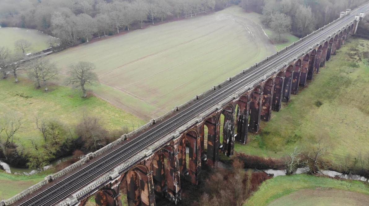 夏のウーズバレー高架橋 バルコンベ高架橋 の眺めで、アーチを通して草の上に明るい太陽が輝いている写真素材1855361557Shutterstock
