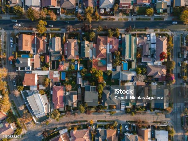 都市の日の出に住宅街の家が飛び交う様子を映したドローン映像。家の間には緑や植生が豊かに見え、道路や駐車した車が見えます」の動画素材 ロイヤリティフリー 1103613373Shutterstock