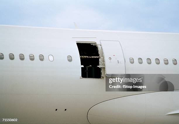 客室乗務員はプライベート飛行機のジェット機のドアを閉めました。現代の旅客機。真面目な混血の男は制服を着ています。晴れた日中。民間商用航空。空の旅のコンセプトPremium写真