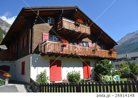 スイスアルプス、背景に山がある家の写真・画像素材-Snapmart スナップマート